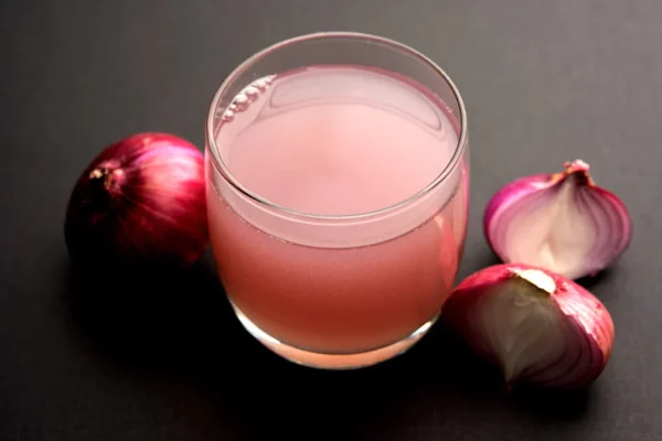 Glass of onion juice with onions as a natural hair loss treatment at hairloss-recovery